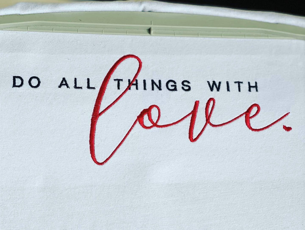 Embroidery design with the phrase 'Do all things with love' written in stylish lettering